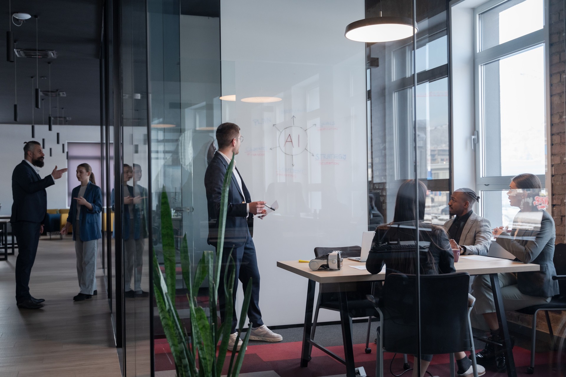 Modern office meeting with diverse professionals discussing artificial intelligence strategy. Concept of teamwork, technology, and corporate innovation in a contemporary workspace